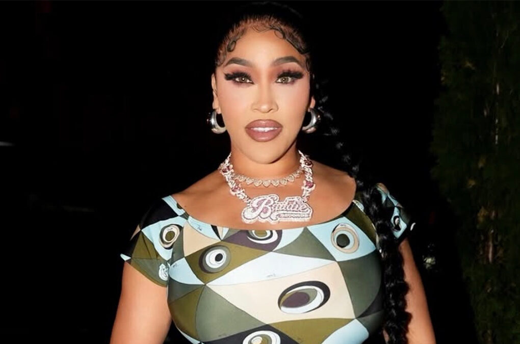 Rapper & Reality TV Star Natalie Nunn Rocks Emilio Pucci Occhi-Print Off-The-Shoulder Fitted Jumpsuit In NYC, Paired With Silver Chanel Mini Hobo Purse ($9,000), Giuseppe Zanotti New Cruel 105 Silver Heels, & New Baddie Records Platinum $150,000 Necklace